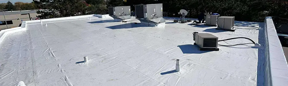 Top view on a bright sunny day of a large Duro-Last PVC commercial roofing membrane after being newly installed by Flint Ideal Roofing's business roof installations service in Flint Michigan.