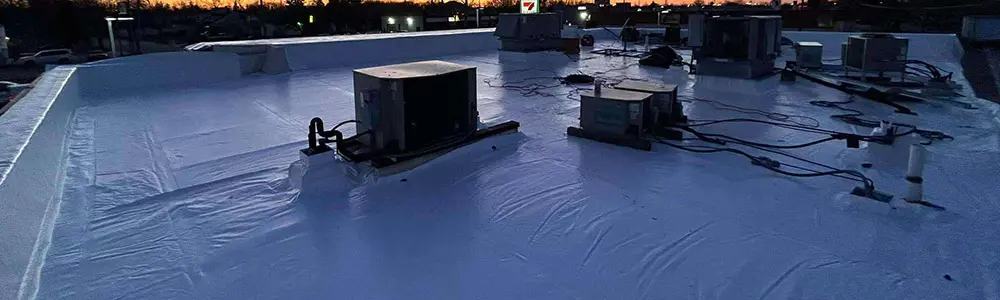 A top view while the sun is setting of a large Duro-Last PVC commercial roofing membrane after being newly installed by Flint Ideal Roofing's commercial roof replacements service in Flint Michigan.