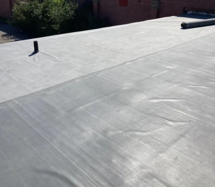 new pvc membrane being installed on a commercial flat roof in clio