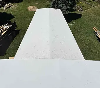 Top view showing of a red caboose with a white Duro Last roofing system in Owosso, MI that was installed by a roofing contractor that provides installations and repairs beyond just commercial roofing in Flint.