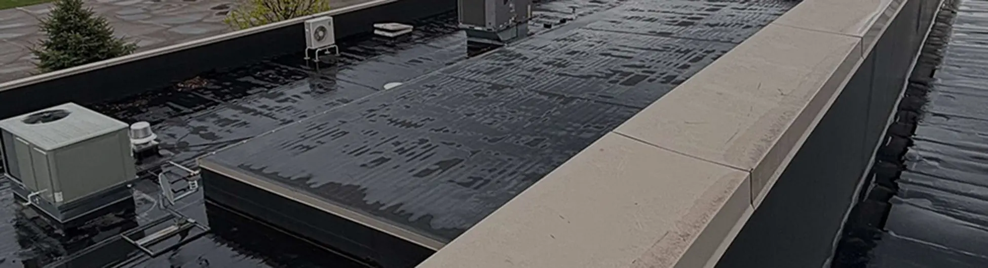 Ideal Roofing contractor inspecting a commercial roof in Grand Blanc.