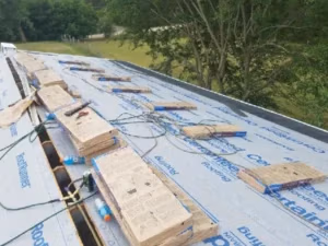 Michigan home roofing tear off with new bundles of dimensional shingles ready to install by Ideal Roofing LLC.