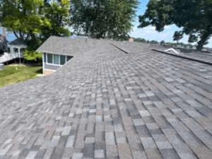 New installation of gray architectural shingles on a lakeside home by Ideal Roofing.