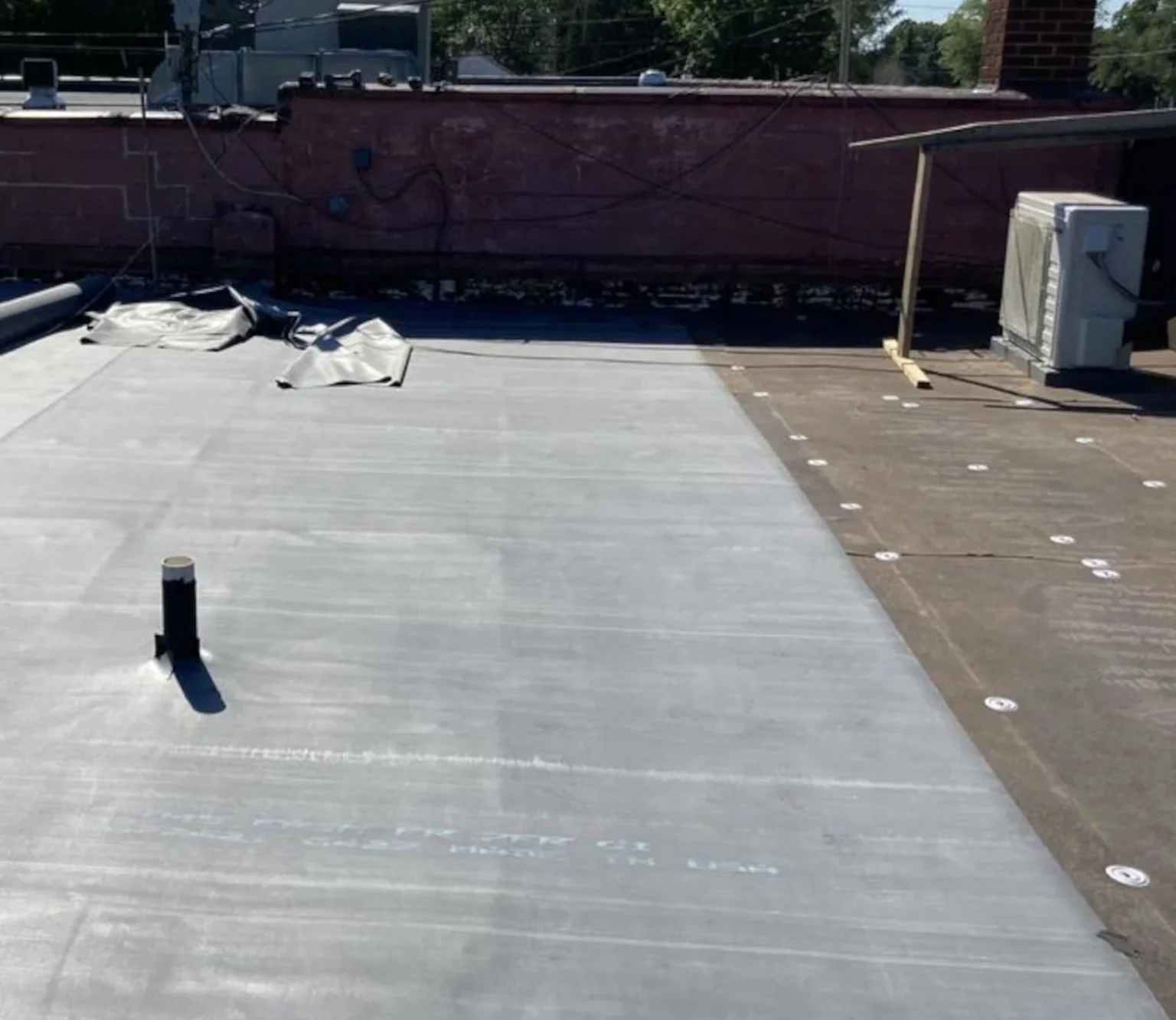 new pvc membrane being installed on a commercial flat roof in clio