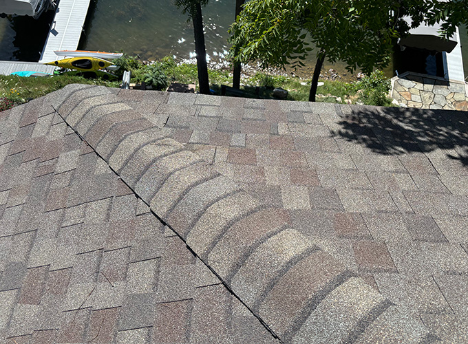 Storm damage roof insurance claims for heavy wind damaged asphalt shingles on roof after expert roofing repairs