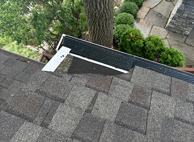 View of missing roofing shingles from storm damage used for ideal roofing's roof insurance claims guide.