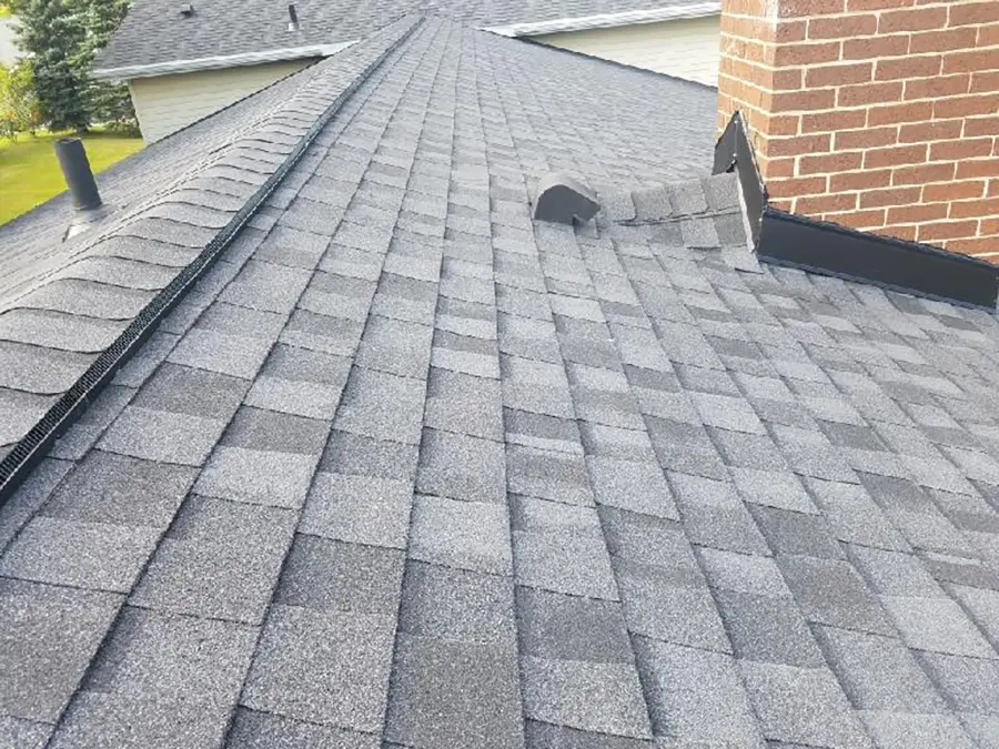 A new asphalt shingle roof around the chimney and vent pipe after it was installed by Ideal Roofing LLC which is a saginaw michigan roofing contractor based out of Flint Michigan. 